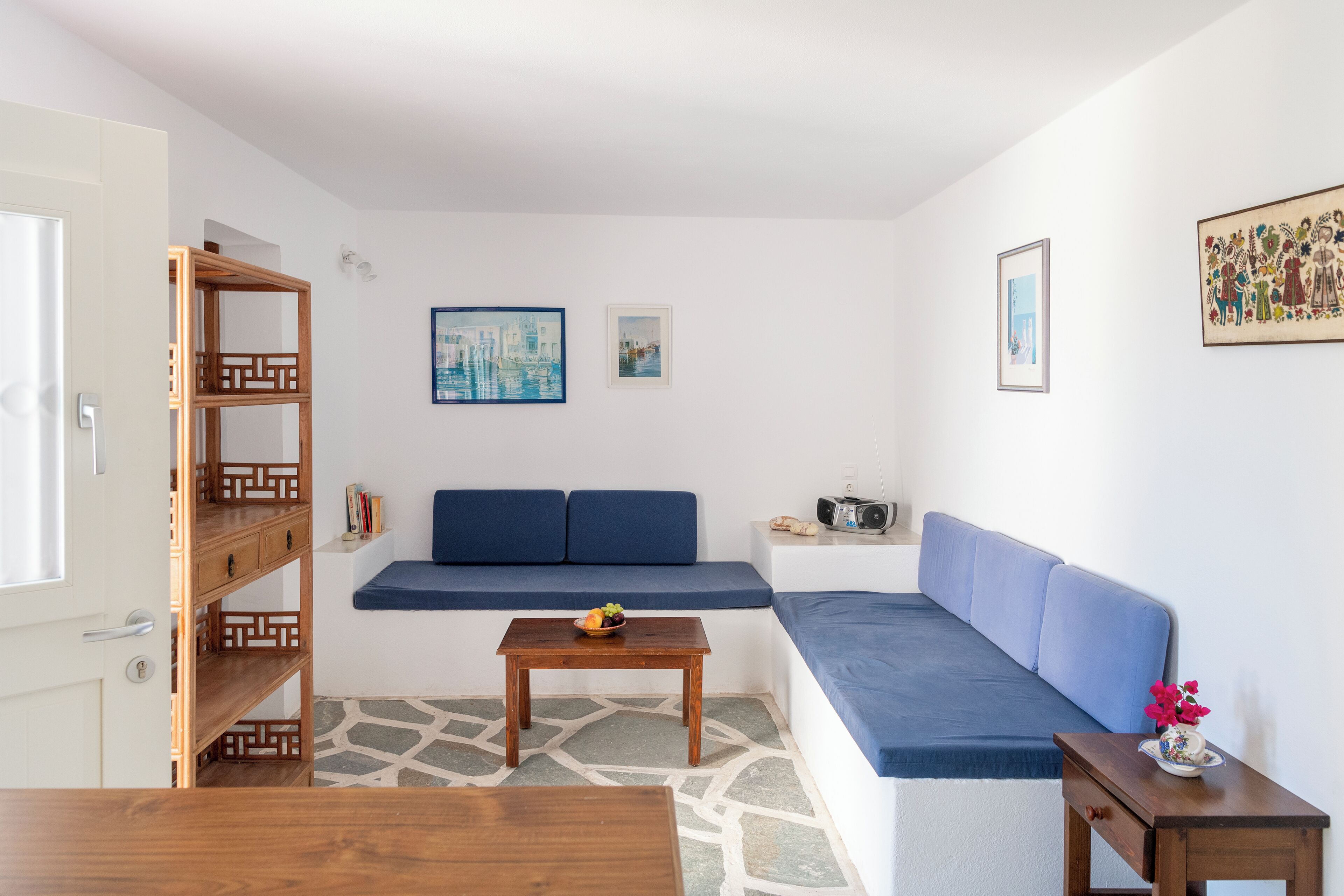 Un salon moderne avec un canapé bleu, une table basse en bois et une bibliothèque.