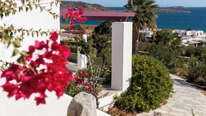 A coastal property with a stone pathway, white walls, and a view of the sea.