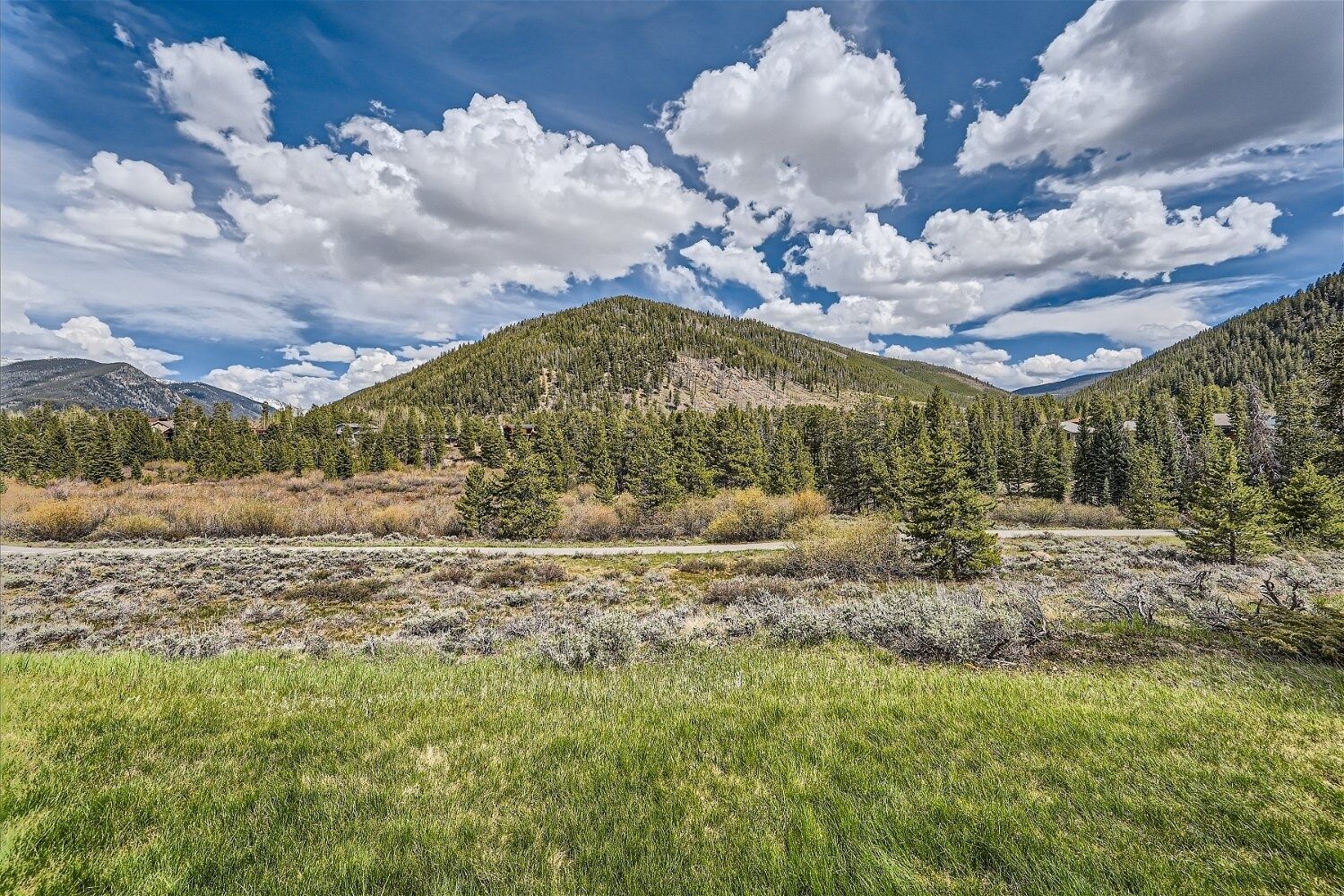 A mountainous landscape with a clear sky and scattered clouds.