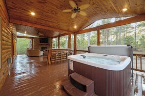 A wooden cabin with a hot tub, bar area, and a fireplace. - The Rustic Ritz|2BD 2BTH|Hot tub|Shuffleboard|Luxury|SLPs8 (Broken Bow)