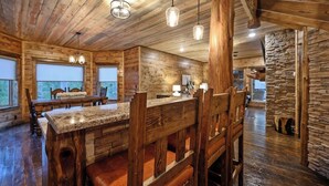 Ein rustikales Holzinterieur mit Barbereich, Steinwänden und einem Essbereich.