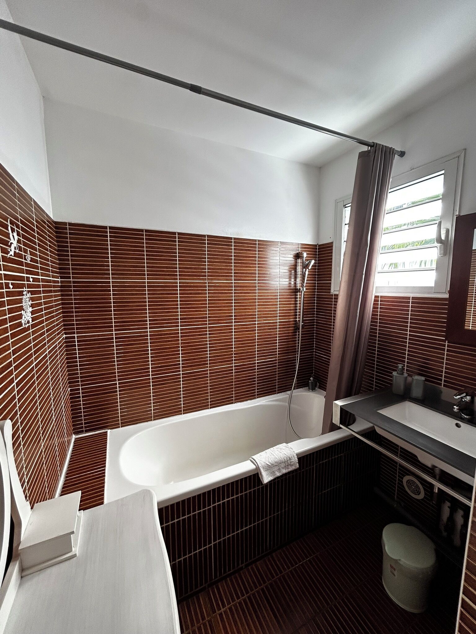 A modern bathroom with a freestanding bathtub, a vanity with a sink, and a toilet.