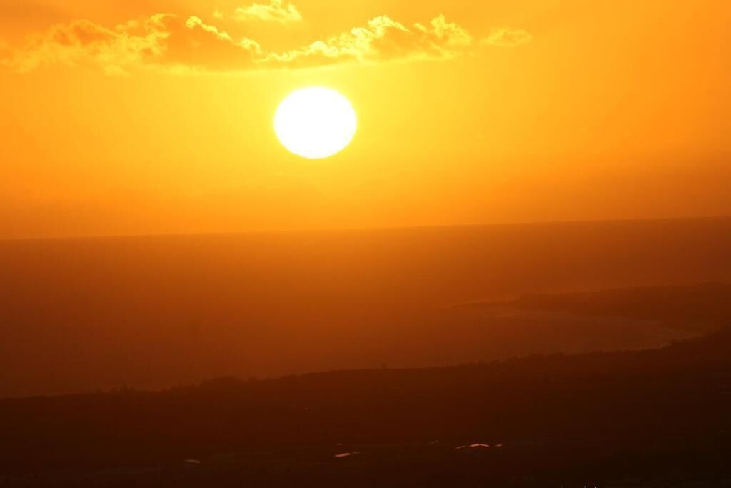 Un atardecer sobre un paisaje montañoso con cielo despejado.