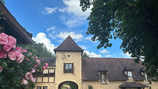 A stone building with a central tower, arched entrance, and multiple windows. - Gites de Charme 18 Personnes Avec Tennis Dans un Parc de 2 ha . Idéal Familles (Montignac-Lascaux)