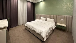Una habitación de hotel moderna con una cama grande, una mesita de noche, un escritorio y una silla.