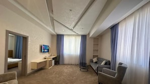 Una habitación de hotel moderna con cama, escritorio, sofá y televisor.