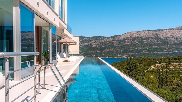A modern hotel with a private infinity pool overlooking a mountainous landscape. - Luxury Villa Morello Korcula 1 with Heated Pool (Korcula)