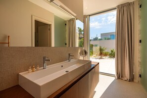 A modern bathroom with a large sink, mirror, and a view of the outdoors. - Luxury Villa Morello Korcula 2 with Heated Pool (Korcula)