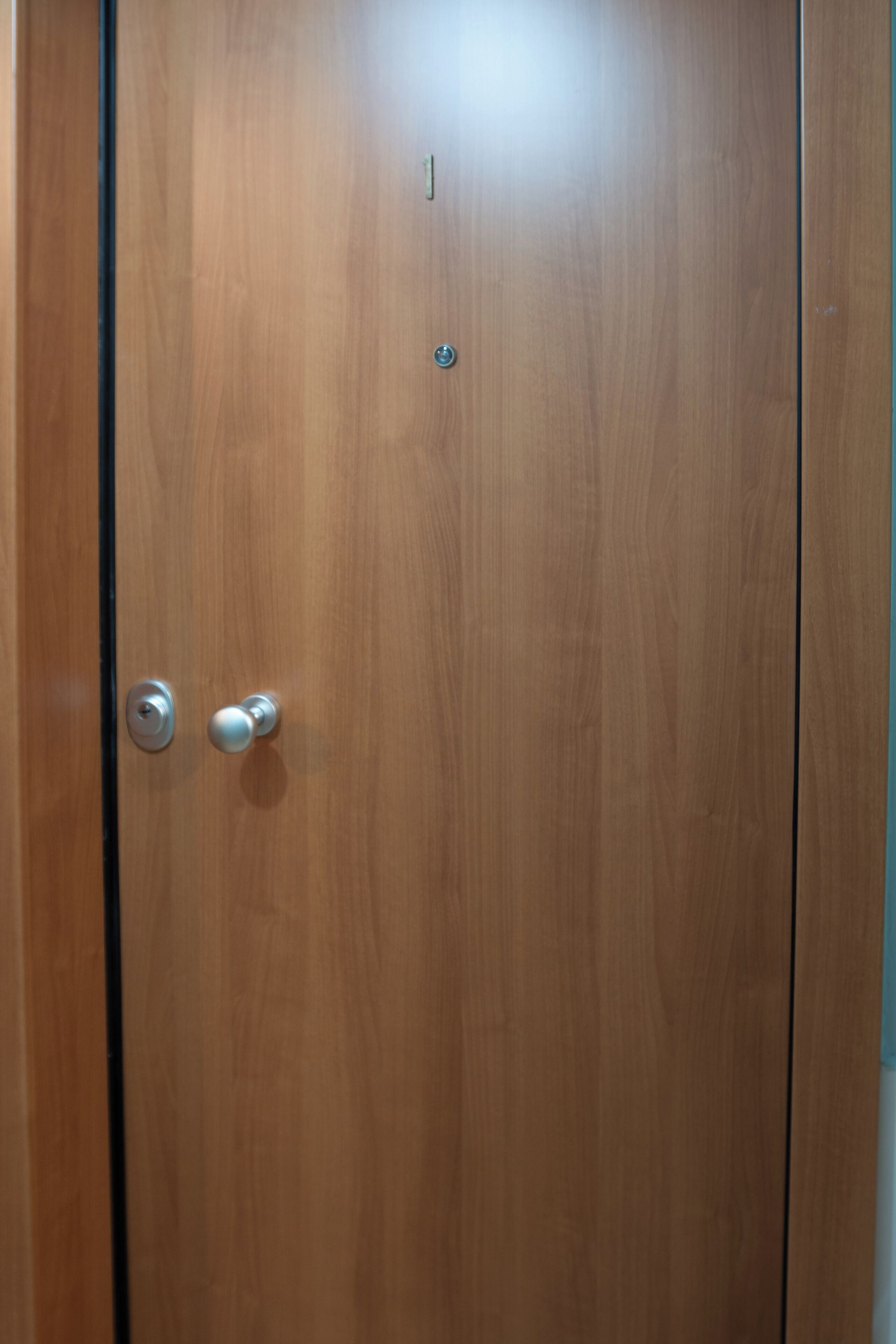 A wooden door with a round handle and a keyhole.