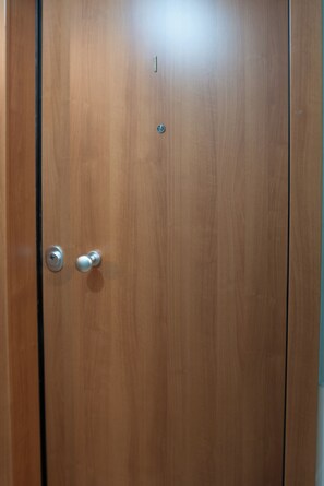 A wooden door with a round handle and a keyhole.