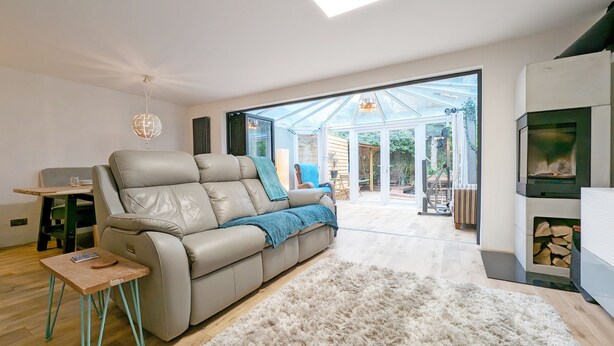 Un salon moderne avec un canapé en cuir, une petite table en bois, un tapis moelleux et une cheminée.
