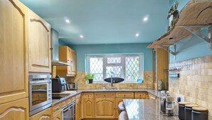 Une cuisine avec des meubles en bois, un plan de travail en granit et une fenêtre donnant sur un beau paysage.
