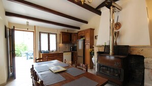 Un comedor con mesa de madera, sillas y chimenea.