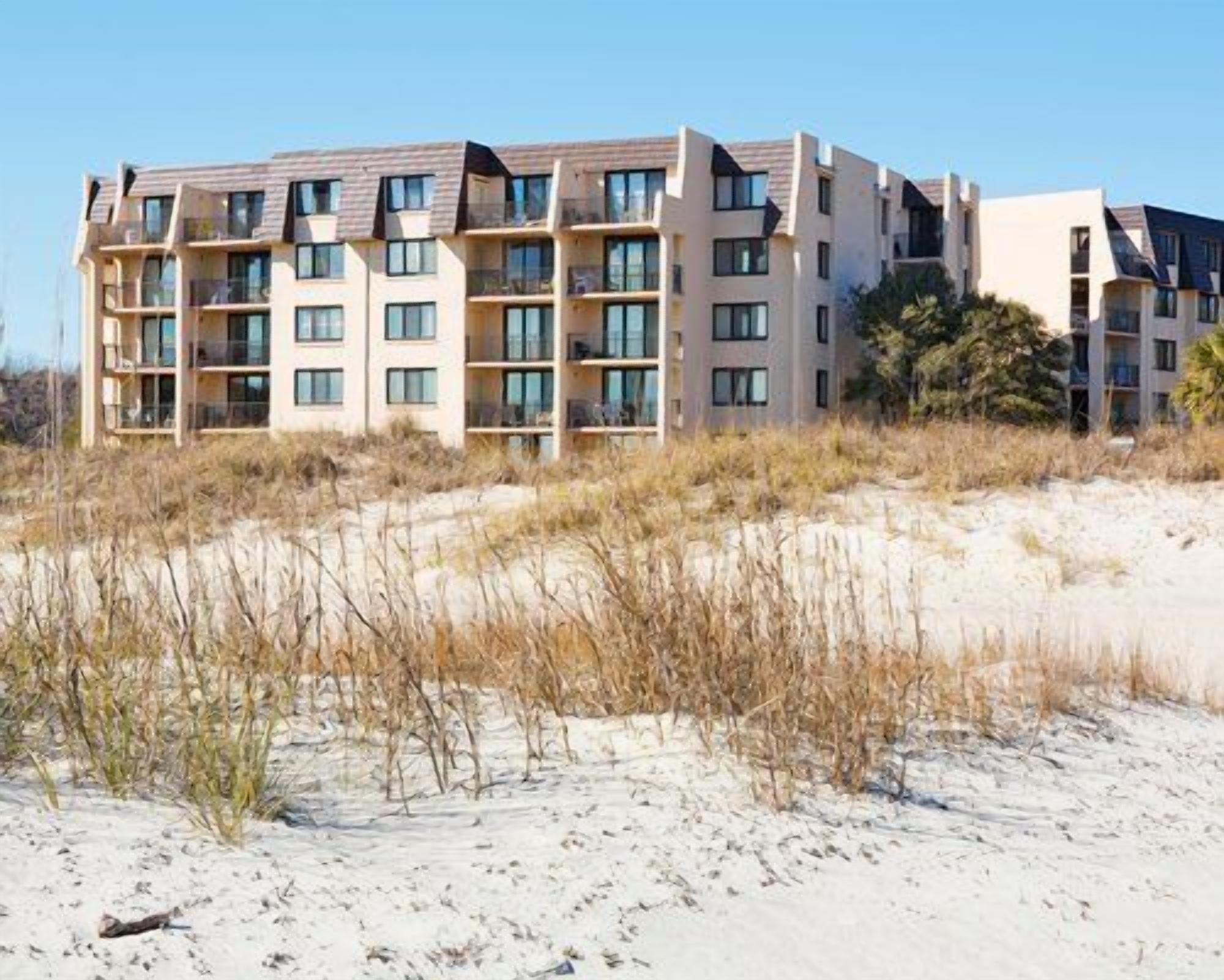 A multi-story hotel with a modern architectural design, featuring balconies and large windows.