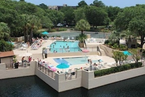 A pool area with multiple swimming pools, sun loungers, and umbrellas. - 4203 Island Club - Folly Field - 2 Bed 2 Bath Sleeps 5 - Hilton Head Rentals (Hilton Head Island)