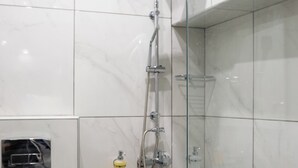 A modern bathroom with a glass-enclosed shower, a toilet, and a sink. - Pagrati Studio New Chic and Central (Athens)