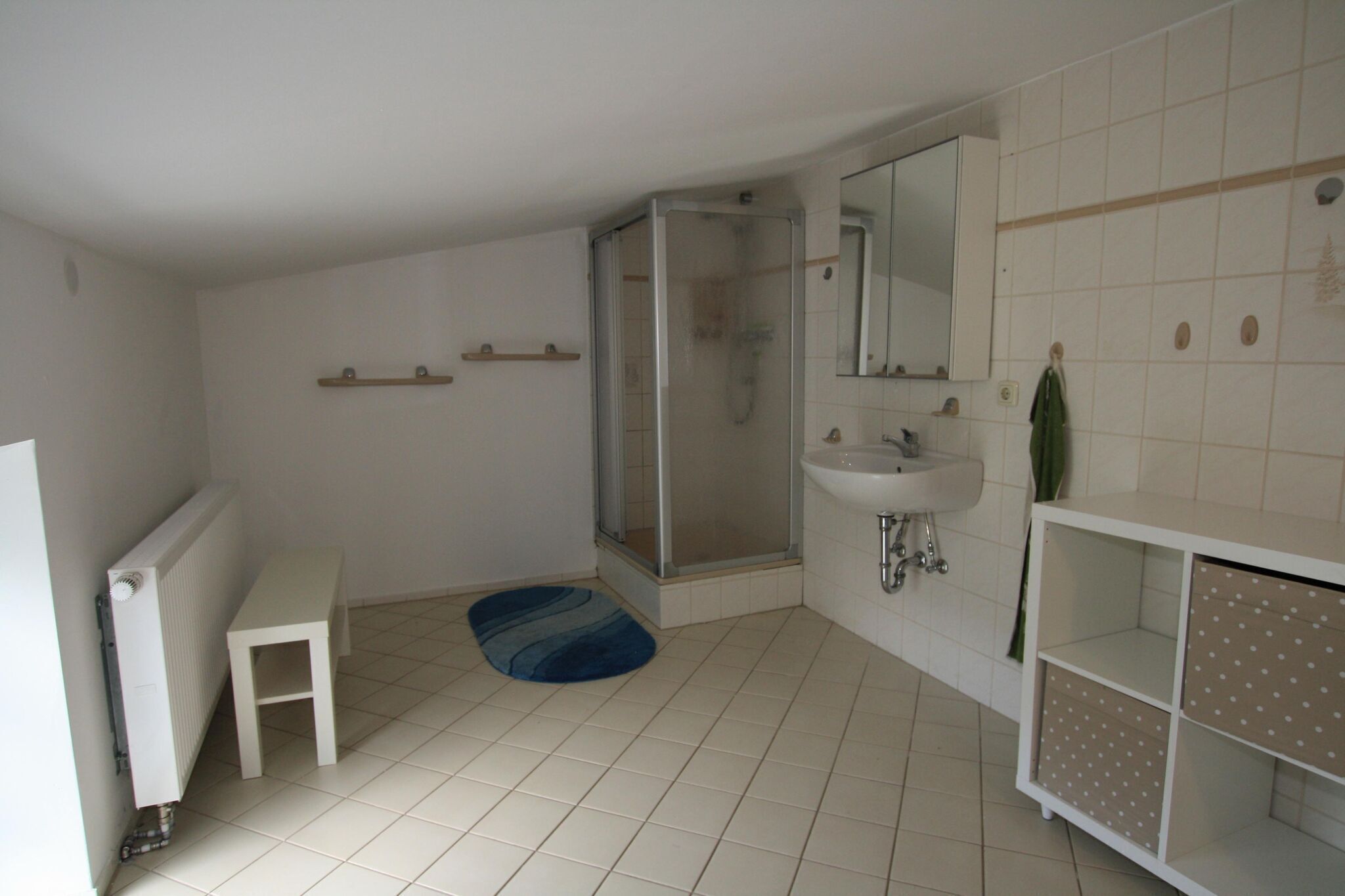 Ein Badezimmer mit Dusche, Waschbecken und einem kleinen Tisch.