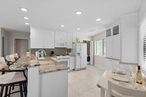 Enjoy cooking in this well-equipped kitchen with a central island, sink, microwave, dishwasher, and refrigerator.