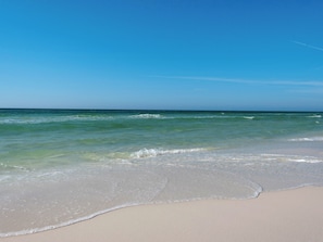 Una spiaggia con acque cristalline e una riva sabbiosa.