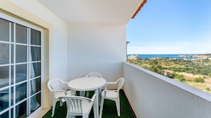Enjoy a serene coastal view from this room's spacious balcony, featuring a table and chairs.