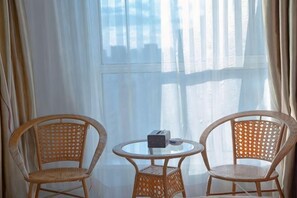 Two wicker chairs and a small round table with a box and a tissue. - Dalian Kaiyuan Hotel (Dalian)