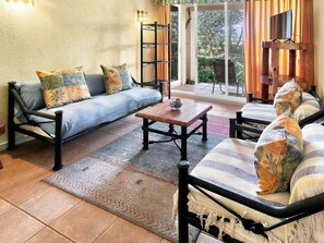 A cozy living room with a sofa, armchairs, a coffee table, and a bookshelf. - Oceana Suites Bahía Pelicanos (Puchuncavi)
