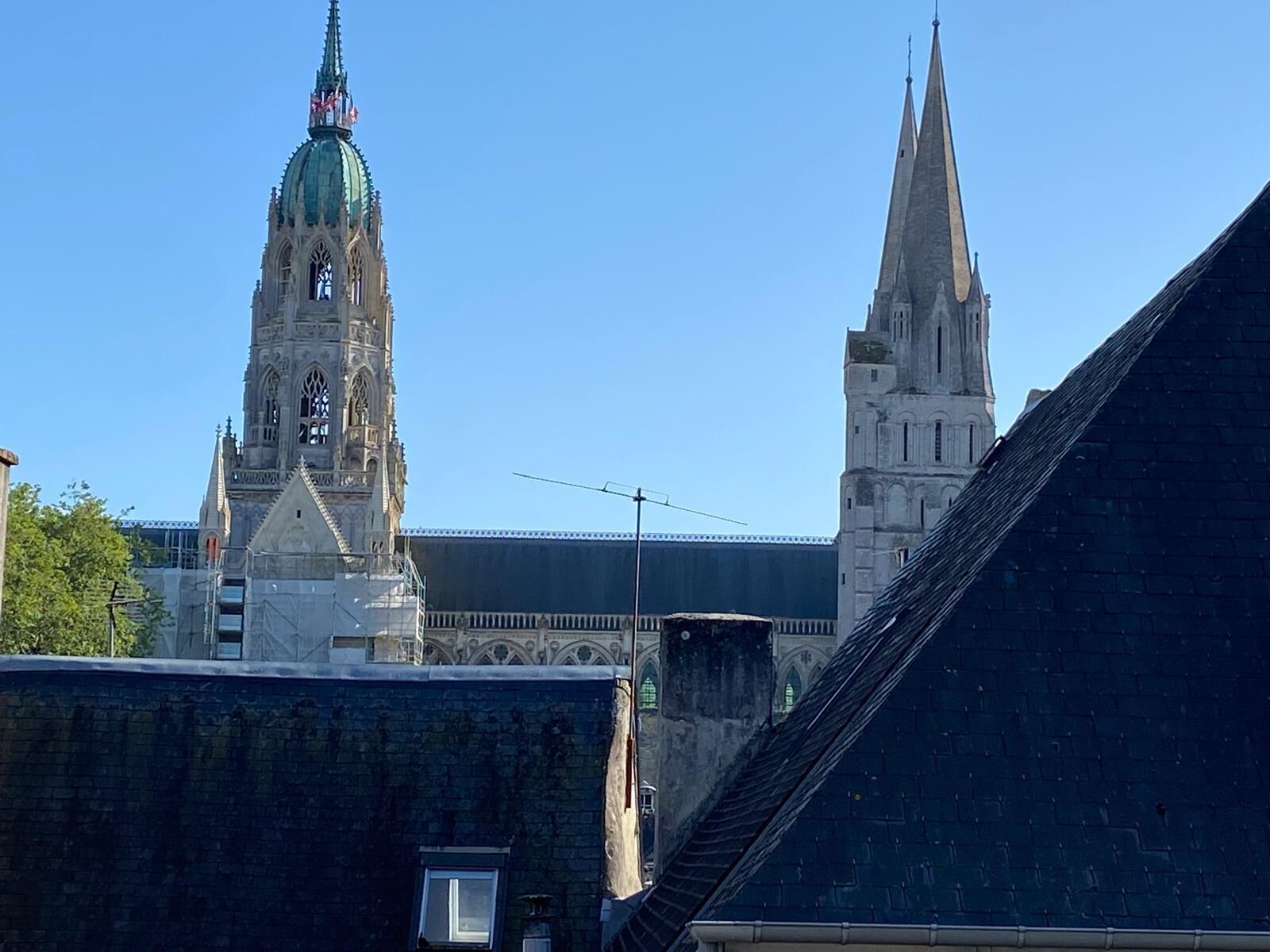 Uma igreja histórica com uma torre imponente e uma cúpula, cercada por edifícios urbanos.