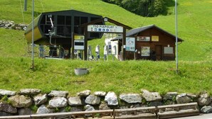 Un chalet de montagne avec un télésiège, un panneau indicateur et une cabane en bois.