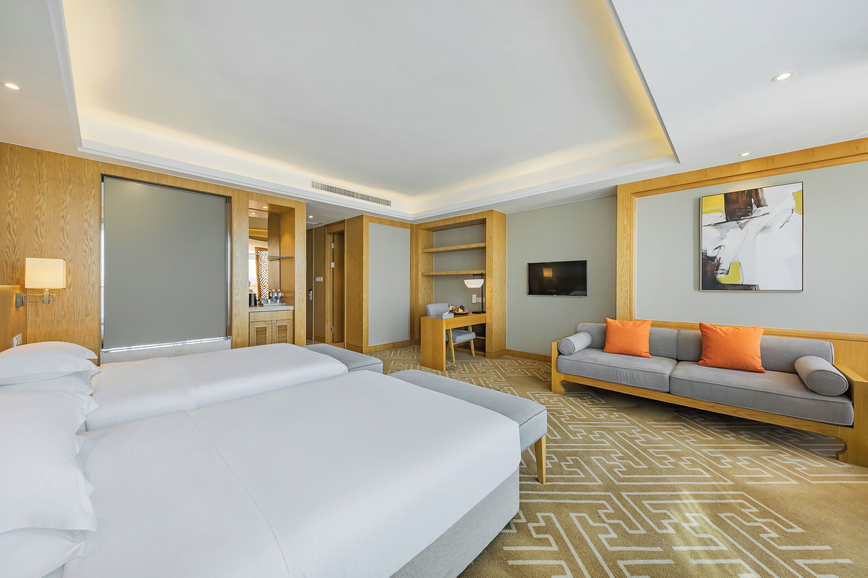 Una habitación de hotel con una cama grande, un sofá, un escritorio y un televisor.