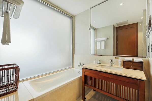 A modern bathroom with a bathtub, a wooden vanity, a large mirror, and a towel rack. - Courtyard By Marriott Anji (Huzhou)