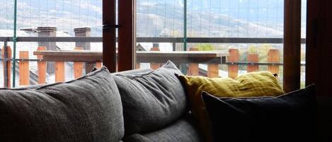 A room with a grey sofa, a yellow pillow, and a black pillow.