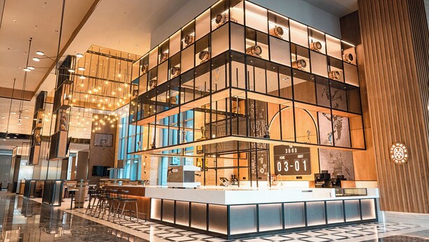 A modern hotel lobby with a central reception desk, a large chandelier, and a patterned floor. - Four Points By Sheraton Yantai (Yantai)