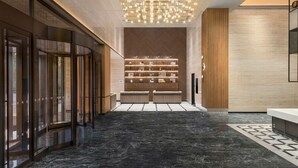 A modern lobby with a marble floor, a central display of items, and a unique ceiling light fixture. - Four Points By Sheraton Yantai (Yantai)