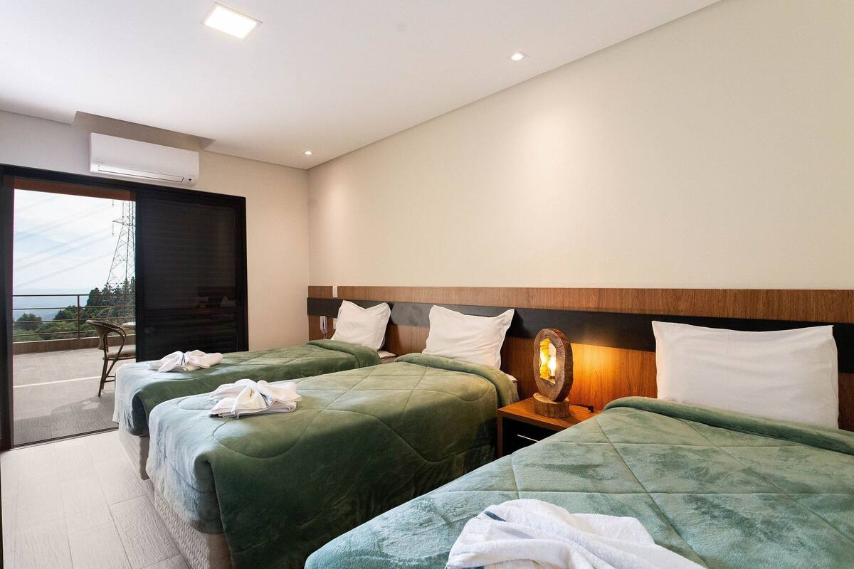 Une chambre d’hôtel avec deux lits, un balcon et une vue sur le panorama urbain.