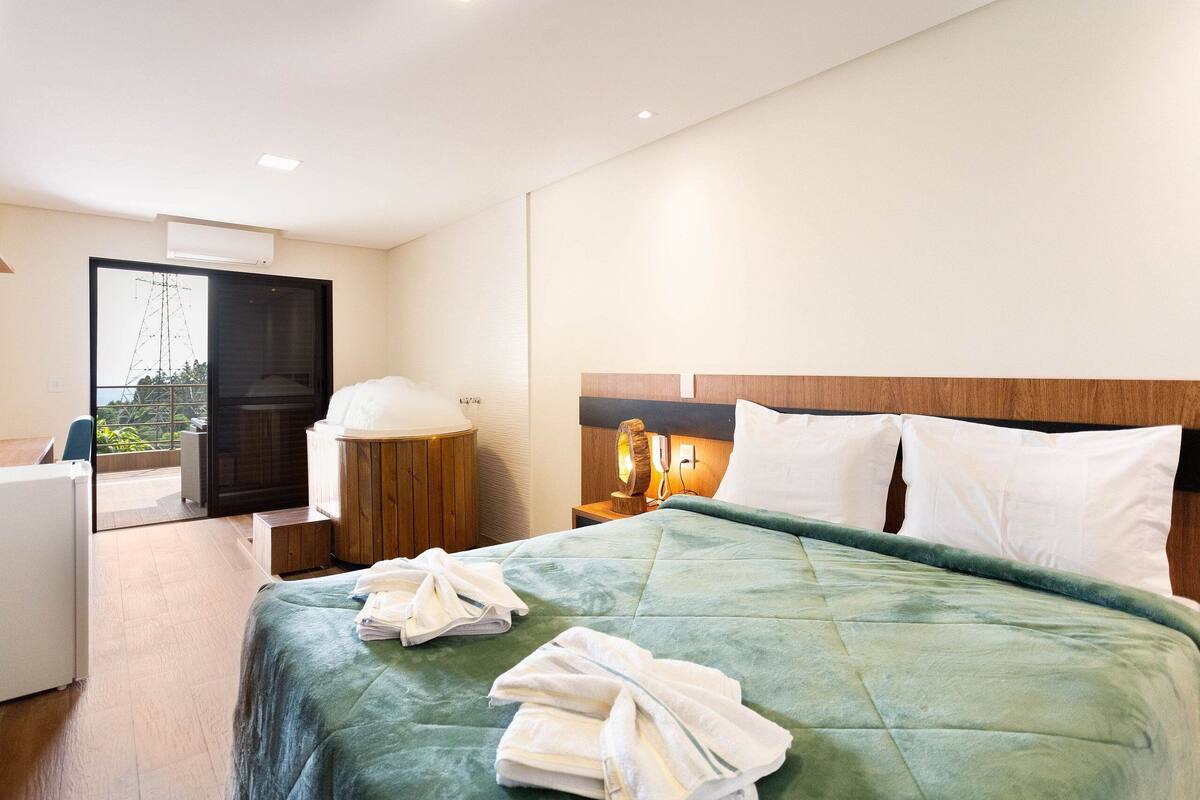 Une chambre d’hôtel avec un lit, un bureau et une vue sur l’extérieur.