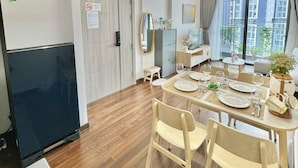 A modern kitchen with a built-in refrigerator, a dining area with a table set for four, and a large window offering a view of the city.