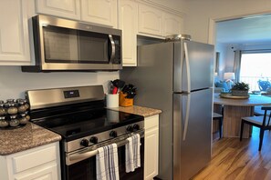 A modern kitchen with stainless steel appliances, including a microwave, stove, and refrigerator.