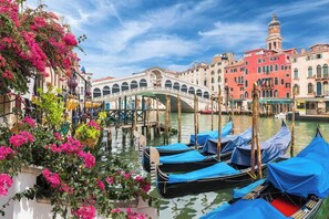 Un canal con góndolas amarradas, un puente y edificios históricos.
