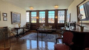Ein geräumiges Wohnzimmer mit großem Fenster, Holzboden, einem roten Sessel und einem Couchtisch.