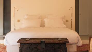 A bedroom with a wooden bed frame, a nightstand, and a chair.