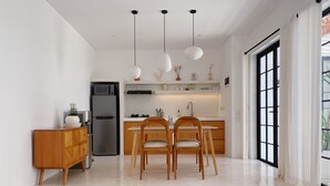 Une cuisine moderne avec un îlot central, des chaises en bois et des luminaires suspendus.
