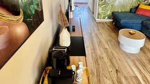Una sala de estar moderna con una mesa de centro de madera, un sofá y un cuadro grande en la pared.
