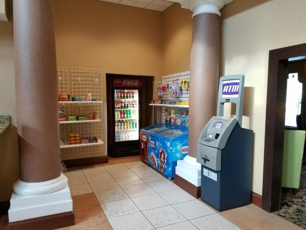 Eine Hotelhalle mit einem Coca-Cola-Kühlschrank, einem Nestlé-Eis-Gefrierschrank und einem Selbstbedienungs-Geldautomaten.