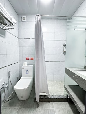 A modern bathroom with a shower, toilet, and sink. - De Villa Hotel (Samarkand)