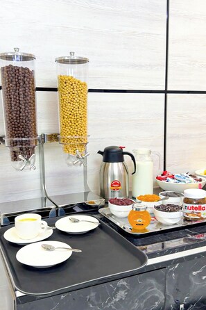 A breakfast buffet setup with various food items and a coffee machine. - De Villa Hotel (Samarkand)
