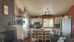 A spacious living area with a fireplace, wooden coffee table, and a sofa. - Beautiful family home in the Upper Rattlesnake (Missoula)