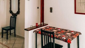 A dining area with a table and chairs, a mirror, and a framed picture on the wall. - Amber apartment  (Essaouira)