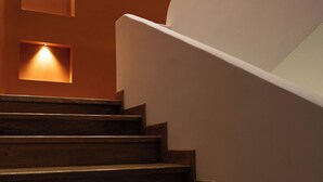 Un escalier avec des marches en bois et des luminaires fixés au mur.