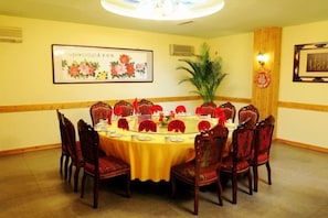 A conference room with a round table, chairs, and floral decorations. - Huailai Diman Hot Spring Resort (Huailai)
