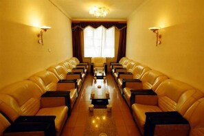 Une pièce avec des canapés en cuir disposés en forme de U autour d’une table basse centrale.